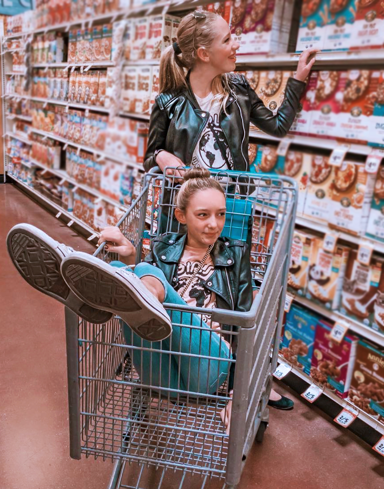 Two girls at grocery store wearing PONY-O ponytail holder and BUN BARZ by PONY-O.