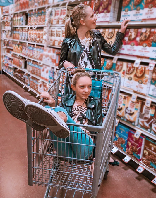 Two girls at grocery store wearing PONY-O ponytail holder and BUN BARZ by PONY-O.